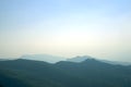 Layer of mountain peaks covered with coniferous deciduous forest