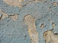 A layer of peeling old blue paint on the relief surface of a concrete cement wallTexture of old white cracked paint on blue concre Royalty Free Stock Photo