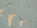 A layer of peeling old blue paint on the relief surface of a concrete cement wallTexture of old white cracked paint on blue concre Royalty Free Stock Photo