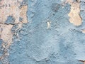 A layer of peeling old blue paint on the relief surface of a concrete cement wallTexture of old white cracked paint on blue concre Royalty Free Stock Photo