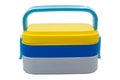 3 layer portable lunch box, yellow, blue, white on white background. Royalty Free Stock Photo