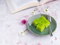 Layer sweet cake on a plate and a cup of white coffee with a book on gray stone background Royalty Free Stock Photo