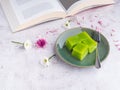 Layer sweet cake on a plate and a cup of white coffee with a book on gray stone background Royalty Free Stock Photo