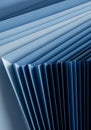 Layered blue paper sheets are arranged in a fan-like pattern, creating a series of para Royalty Free Stock Photo