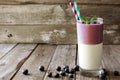 Layered blueberry and coconut smoothie against a rustic wood background Royalty Free Stock Photo