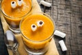 Layered dessert Halloween pumpkin smoothie, decorated with eyes Royalty Free Stock Photo