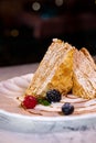 layered dessert napoleon with a berry on a white plate close-up