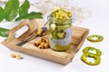 Layered green fruit smoothie in glass with chia seed pudding topped with star shaped banana and kiwi slices on wooden tray Royalty Free Stock Photo