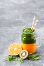 Layered healthy smoothie with spinach, kiwi, orange and mango