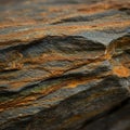 Layered metamorphic rock features alternating bands of rust-colored and dark gray