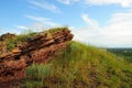 A layered rock formation on top of a grassy hill overlooking a picturesque valley Royalty Free Stock Photo