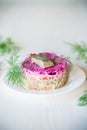 layered salad of boiled vegetables with beets and herring on a plate Royalty Free Stock Photo