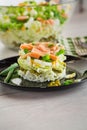 Layered salad of cabbage and other vegetables with pieces of red fish in a plate. Royalty Free Stock Photo