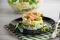 Layered salad of cabbage and other vegetables with pieces of red fish in a plate. Royalty Free Stock Photo