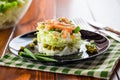 Layered salad of cabbage and other vegetables with pieces of red fish in a plate. Royalty Free Stock Photo