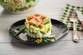 Layered salad of cabbage and other vegetables with pieces of red fish in a plate. Royalty Free Stock Photo