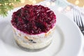 Layered salad with herring, beets, carrots, onions, potatoes close-up on a plate