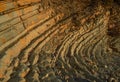 Layered sandy red orange light twisted cliffs made of stone bricks on Black Sea coast, in Blue Bay Golubaya Bay, near Gelenzhik. Royalty Free Stock Photo