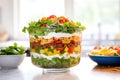 layered taco salad in a trifle bowl, layers visible