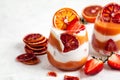 Layered trifle dessert with blood oranges cream Kurd, greek yogurt, Savoyardi cookies, orange chips and strawberry in serving Royalty Free Stock Photo