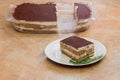 Layers of creamy cocoa, coffee, and cheese in a visible glass tray containing homemade Tiramisu on a rustic countertop Royalty Free Stock Photo