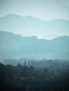 Layers of silhouettes of mountain ranges in fog, mist or smoke. Vertical banner nature landscape in blue color Royalty Free Stock Photo