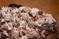 Layers of varigated frosting swirled on top of a thin single layer coffee flavored cake set on a table in a kitchen