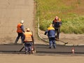 Laying asphalt by workers. Road construction. Modern technology of laying a highway with a solid surface. People work at a