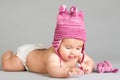 Laying baby in stripy pink cap