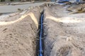 Laying a blue electrical cable in a trench in the ground. Underground communications. Electrical work at the construction site Royalty Free Stock Photo