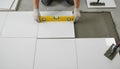 Laying Ceramic Tiles On Adhesive Bed Carefully, Precise Arrangement Of White Ceramic Tiles Using Spacers And Tools For Royalty Free Stock Photo