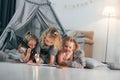 Laying down in the tent with flashlight and pencils to draw. Group of children is together at home at daytime Royalty Free Stock Photo