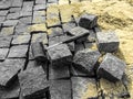 Laying granite paving stones - building background with copy space. A black rubber mallet lies among gray rectangular blocks of