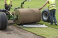laying grass in a roll on a football field