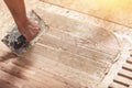 Laying hardwood parquet. Worker installing wooden laminate flooring. Putting glue on the floor. Close up. Copy space for text