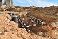 Laying heating pipes in trench at construction site. Installing concrete sewer wells and underground storm systems of sanitary Royalty Free Stock Photo