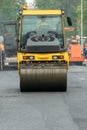 Laying of new modern asphalt. Asphalt laying equipment works on the site. A yellow asphalt skating rink rides in close-up on a new