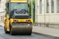 Laying of new modern asphalt. Asphalt laying equipment works on the site. A yellow asphalt skating rink rides in close-up on a new