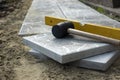 Laying a paving stone or brick. Gray concrete slabs in house courtyard on sand foundation base