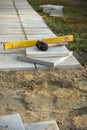 Laying a paving stone or brick. Gray concrete slabs in house courtyard on sand foundation base Royalty Free Stock Photo