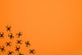 Layout of black spiders on an orange background. Halloween concept.Halloween card. Arachnophobia.Entomophobia.Copy space