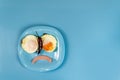 Layout on a blue breakfast plate sad smiley face on a blue table. Blue Monday