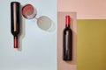 Layout of bottles and glass of red wine on colorful paper background Royalty Free Stock Photo