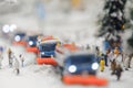 Layout of the city and small figures. Snow-covered road on which snowplows move. Soft focus