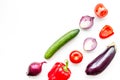 Layout of contrast, colored vegetables. Eggplant, red onion, red pepper, tomato, cucumber on white background top view