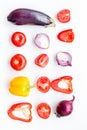 Layout of contrast, colored vegetables. Eggplant, red onion, red pepper, tomato on white background top view pattern