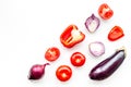 Layout of contrast, colored vegetables. Eggplant, red onion, red pepper, tomato on white background top view copy space