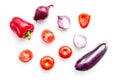 Layout of contrast, colored vegetables. Eggplant, red onion, red pepper, tomato on white background top view pattern