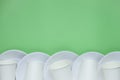 The layout on a green background from paper disposable plates. Caring for the environment. Recycling and sorting of garbage. Royalty Free Stock Photo
