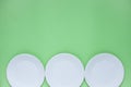 The layout on a green background from paper disposable plates. Caring for the environment. Recycling and sorting of garbage. Royalty Free Stock Photo